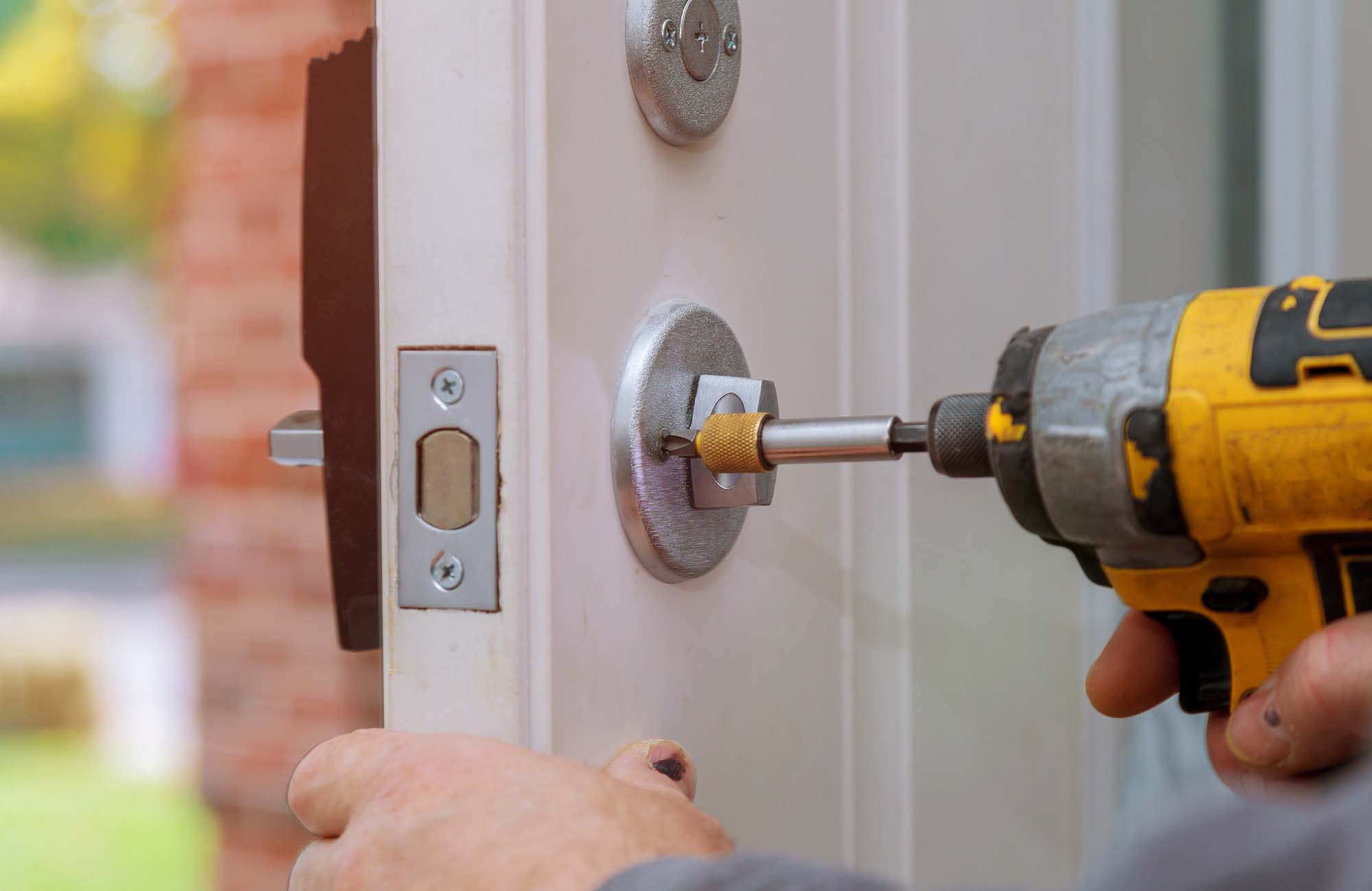Handyman repair the door lock in worker& x27;s hands installing new door locker. handyman repair the door lock in the worker& x27;s hands installing new door locker assembly home drill handle installation locksmith screwdriver manual fixing carpenter construction equipment tool repairman person male service job wood industry house workman craftsman professional metal builder improvement contractor technician knob carpentry security labor industrial deadbolt drilling renovation repairing caucasian in Ashford. Kent