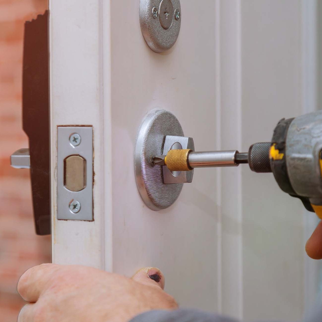 Handyman repair the door lock in worker& x27;s hands installing new door locker. handyman repair the door lock in the worker& x27;s hands installing new door locker assembly home drill handle installation locksmith screwdriver manual fixing carpenter construction equipment tool repairman person male service job wood industry house workman craftsman professional metal builder improvement contractor technician knob carpentry security labor industrial deadbolt drilling renovation repairing caucasian in Ashford. Kent